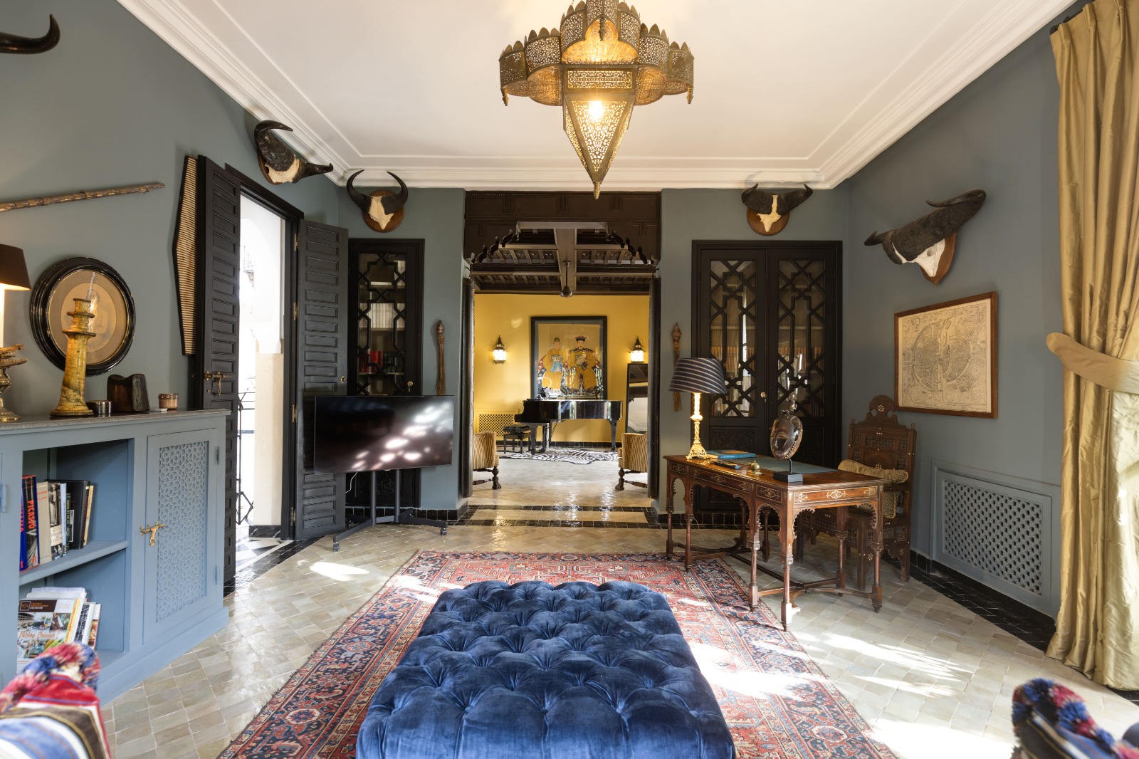 Séjour bleu avec bureau et lustre de la Villa El Moughani